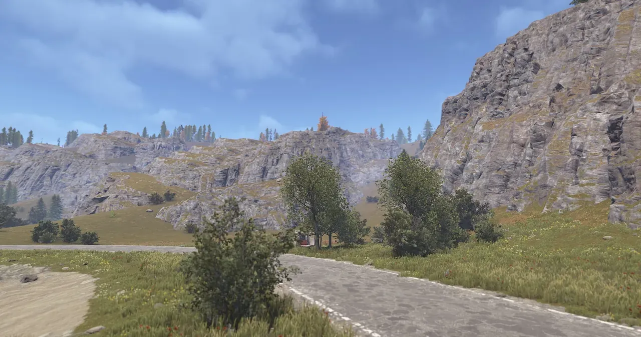 In-game view of a custom Rust map on Crucible terrain: a road winding past cliffs and rolling hills